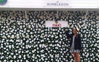 Me stood by a flowery Pimms branded wall at Wimbledon